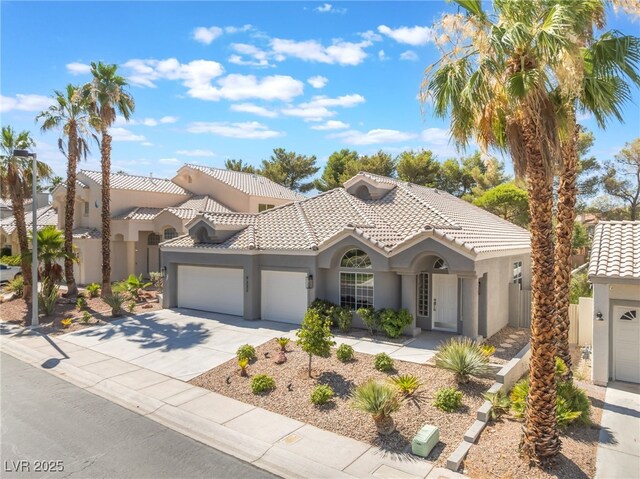 9332 Sienna Vista Dr, Las Vegas, NV 89117 - mediterranean / spanish house with stucco siding, a garage, driveway, and a tiled roof