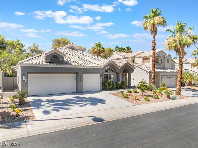 9332 Sienna Vista Dr, Las Vegas, NV 89117 - view of front facade featuring stucco siding, concrete driveway, a garage, and a tile roof