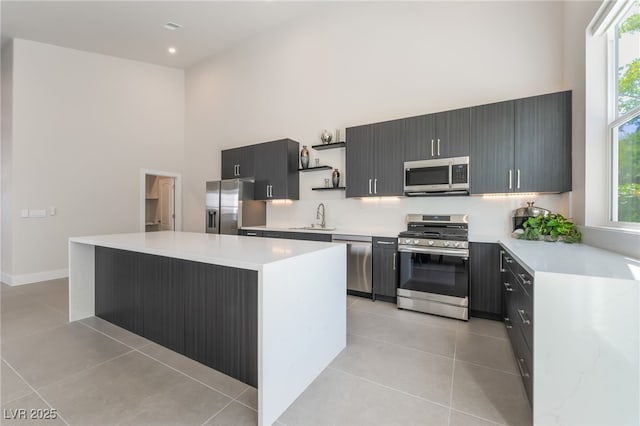 9332 Sienna Vista Dr, Las Vegas, NV 89117 - kitchen featuring stainless steel appliances, a high ceiling, open shelves, light tile patterned floors, and light countertops