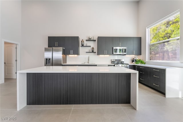 9332 Sienna Vista Dr, Las Vegas, NV 89117 - kitchen with appliances with stainless steel finishes, a towering ceiling, light countertops, open shelves, and light tile patterned floors