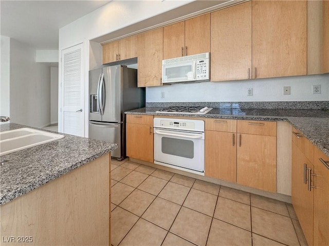 38 E Serene Ave Unit 402, Las Vegas, NV 89123 - kitchen with white appliances, light tile patterned floors, and dark stone counters