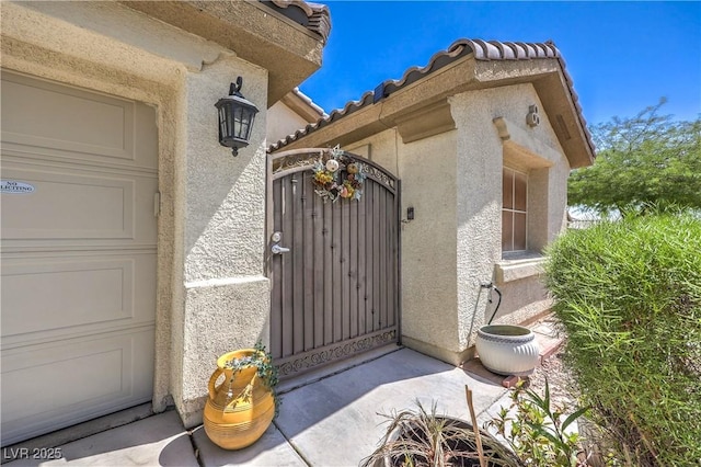 3032 Prairie Princess Ave, North Las Vegas, NV 89081 - view of exterior entry with stucco siding, a gate, and a tile roof