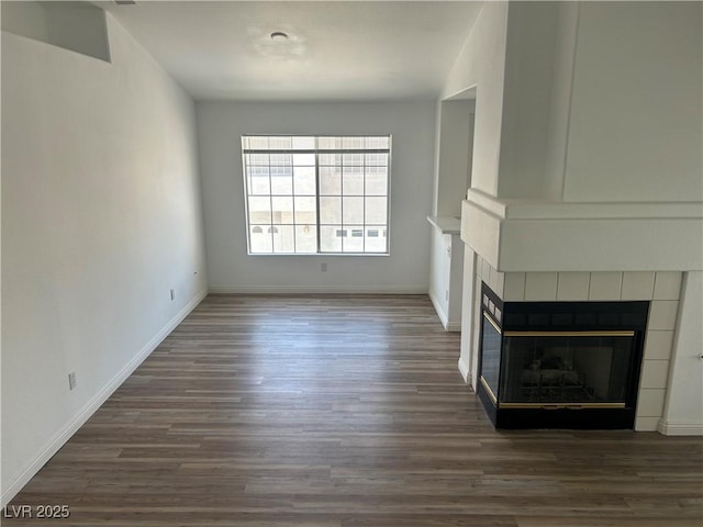 5201 S Torrey Pines Dr Unit 1184, Las Vegas, NV 89118 - unfurnished living room featuring a tiled fireplace and wood finished floors
