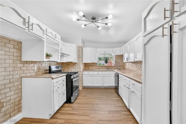 3616 Chevy Chase Ave, Las Vegas, NV 89110 - kitchen with gas range, light countertops, a chandelier, and white cabinetry