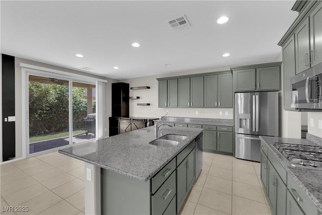 8969 Rice Peak St, Las Vegas, NV 89148 - kitchen featuring appliances with stainless steel finishes, stone countertops, light tile patterned flooring, gray cabinets, and a kitchen island with sink