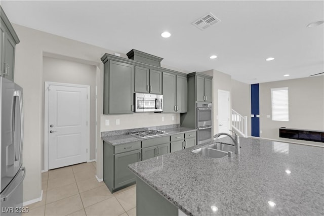 8969 Rice Peak St, Las Vegas, NV 89148 - kitchen featuring stainless steel appliances, light stone countertops, light tile patterned floors, recessed lighting, and open floor plan