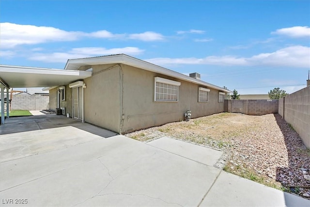 216 Lorenzi St, Las Vegas, NV 89107 - view of home's exterior with a fenced backyard, an attached carport, concrete driveway, and stucco siding