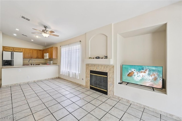 9362 Baltinglass St, Las Vegas, NV 89123 - kitchen with white appliances, light countertops, vaulted ceiling, ceiling fan, and a fireplace