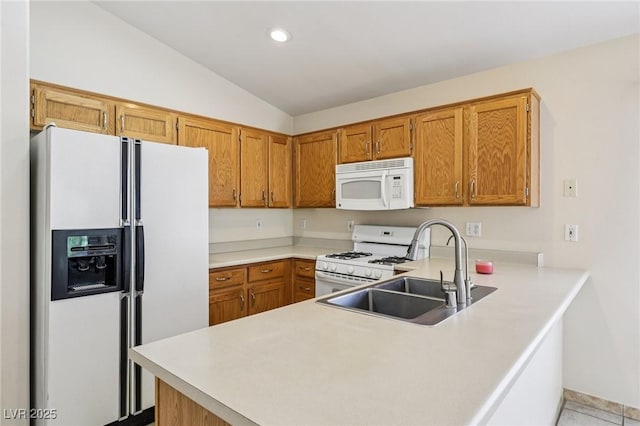 9362 Baltinglass St, Las Vegas, NV 89123 - kitchen with white appliances, a peninsula, lofted ceiling, light countertops, and brown cabinets