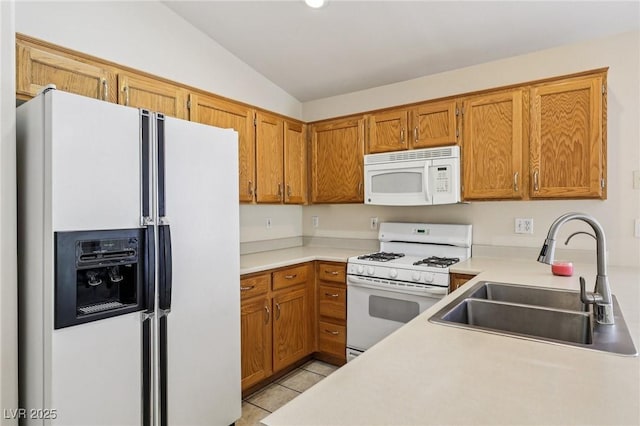 9362 Baltinglass St, Las Vegas, NV 89123 - kitchen featuring white appliances, vaulted ceiling, light tile patterned floors, brown cabinetry, and light countertops