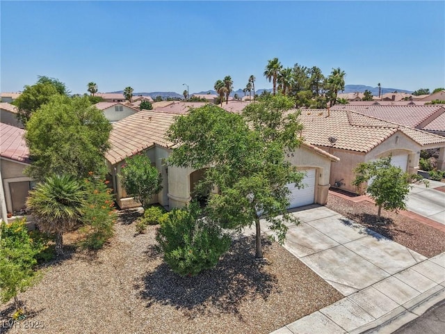 9362 Baltinglass St, Las Vegas, NV 89123 - view of property hidden behind natural elements featuring stucco siding, a tiled roof, driveway, an attached garage, and a residential view