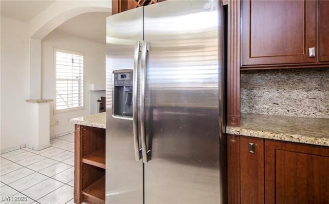 4466 New Dupell Way, Las Vegas, NV 89147 - kitchen featuring stainless steel refrigerator with ice dispenser, arched walkways, decorative backsplash, and light stone counters