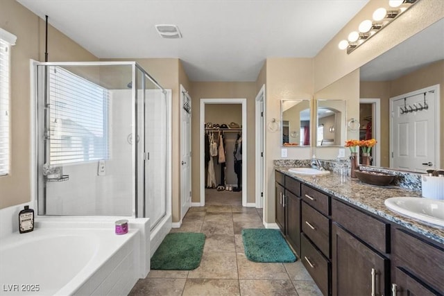 5309 Golden Melody Ln, North Las Vegas, NV 89081 - bathroom featuring a stall shower, double vanity, a walk in closet, and a bath