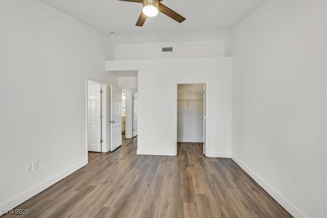 2820 Golf Links Dr, Las Vegas, NV 89134 - unfurnished bedroom featuring wood finished floors, a spacious closet, a closet, and a ceiling fan