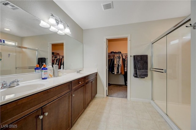 10722 Red Badge Ave, Las Vegas, NV 89166 - full bath featuring a spacious closet, a shower stall, double vanity, and tile patterned floors