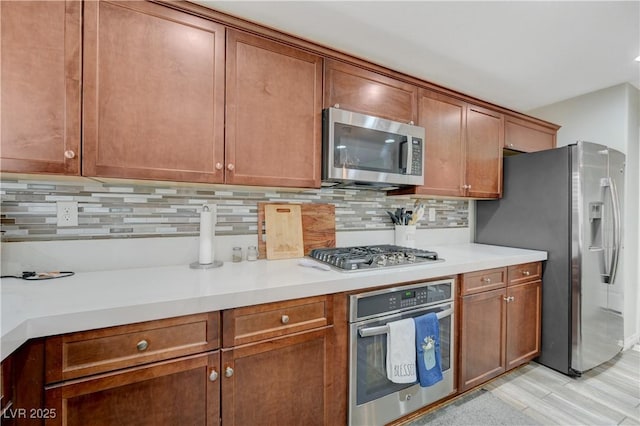 10722 Red Badge Ave, Las Vegas, NV 89166 - kitchen with appliances with stainless steel finishes, backsplash, light countertops, and brown cabinetry
