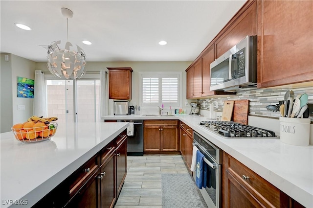10722 Red Badge Ave, Las Vegas, NV 89166 - kitchen with appliances with stainless steel finishes, light countertops, a chandelier, backsplash, and recessed lighting