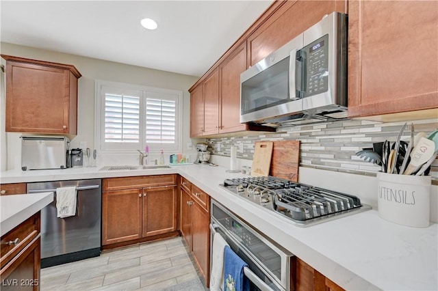 10722 Red Badge Ave, Las Vegas, NV 89166 - kitchen with appliances with stainless steel finishes, light countertops, tasteful backsplash, recessed lighting, and brown cabinetry