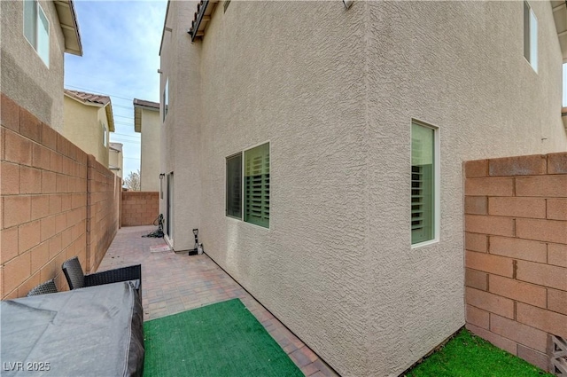 10722 Red Badge Ave, Las Vegas, NV 89166 - view of side of home featuring stucco siding, a fenced backyard, and a patio area