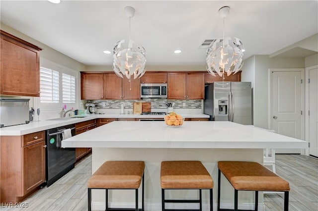 10722 Red Badge Ave, Las Vegas, NV 89166 - kitchen featuring stainless steel appliances, a chandelier, a breakfast bar area, light wood-style flooring, and backsplash