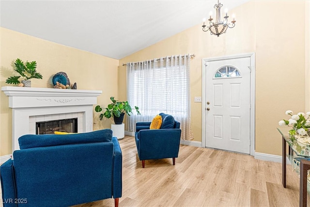 8611 Gabilan Ct, Las Vegas, NV 89123 - living room with a chandelier, light wood-type flooring, lofted ceiling, and a tiled fireplace
