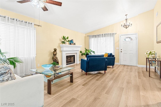 8611 Gabilan Ct, Las Vegas, NV 89123 - living area with vaulted ceiling, light wood-type flooring, a ceiling fan, a chandelier, and a fireplace