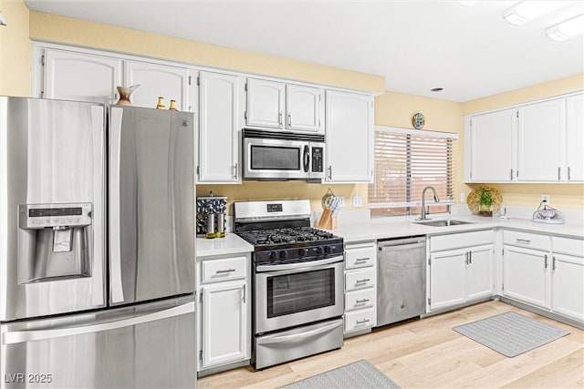8611 Gabilan Ct, Las Vegas, NV 89123 - kitchen featuring stainless steel appliances, light countertops, light wood-style floors, and white cabinetry