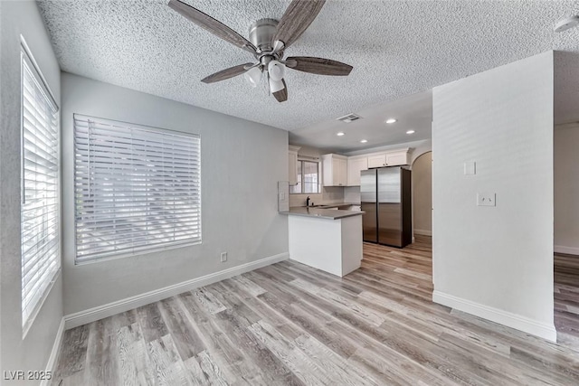 2200 S Fort Apache Rd Unit 2209, Las Vegas, NV 89117 - kitchen featuring freestanding refrigerator, a textured ceiling, a ceiling fan, a peninsula, and light wood-style floors