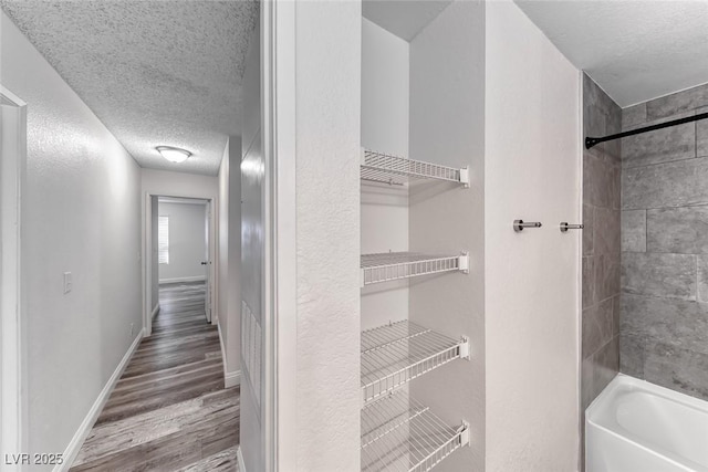 2200 S Fort Apache Rd Unit 2209, Las Vegas, NV 89117 - bathroom featuring a textured ceiling, wood finished floors, and washtub / shower combination