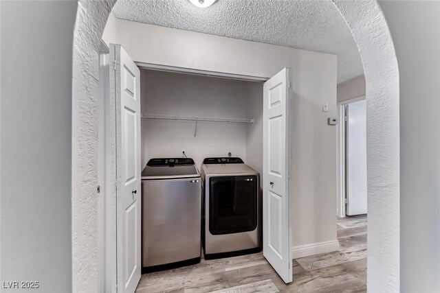 2200 S Fort Apache Rd Unit 2209, Las Vegas, NV 89117 - laundry area with independent washer and dryer, light wood-type flooring, arched walkways, and a textured ceiling