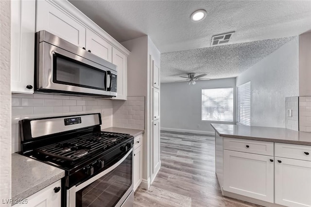 2200 S Fort Apache Rd Unit 2209, Las Vegas, NV 89117 - kitchen with stainless steel appliances, a textured ceiling, ceiling fan, white cabinetry, and tasteful backsplash