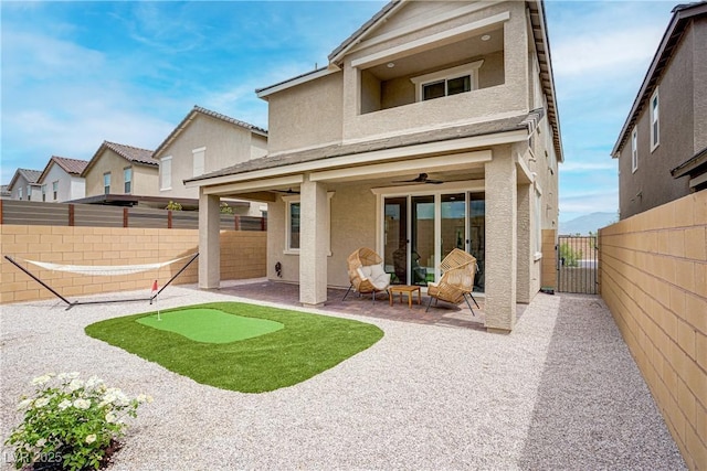 6591 Dove Point Pl, Las Vegas, NV 89130 - rear view of property featuring a putting area, stucco siding, a patio, a gate, and ceiling fan