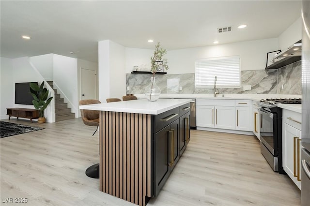 5505 Eagle Cove Ave, Las Vegas, NV 89130 - kitchen featuring range with gas cooktop, a breakfast bar, a kitchen island, light wood-style floors, and recessed lighting