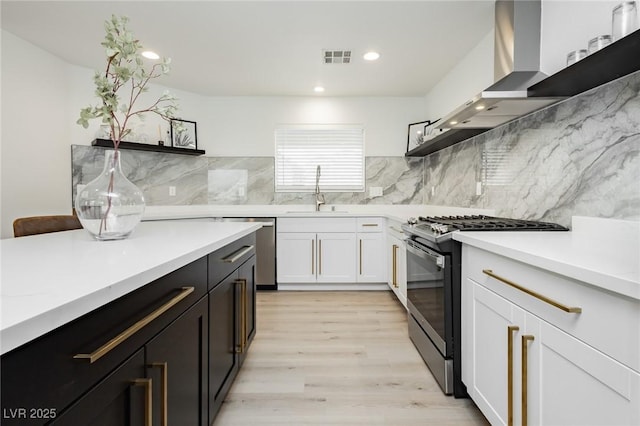 5505 Eagle Cove Ave, Las Vegas, NV 89130 - kitchen featuring gas stove, open shelves, stainless steel dishwasher, wall chimney range hood, and recessed lighting