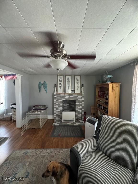 191 S Booker, Tonopah, NV 89049 - living area with a ceiling fan, a tiled fireplace, and wood finished floors