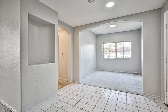 7400 W Flamingo Rd Unit 1051, Las Vegas, NV 89147 - spare room featuring light carpet, arched walkways, and light tile patterned floors