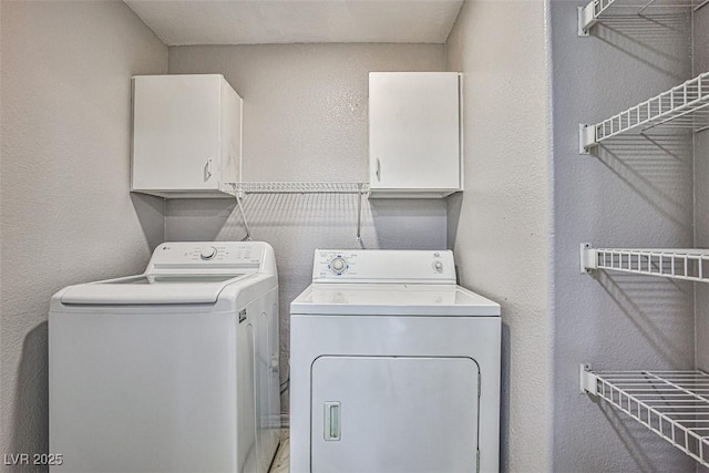 7400 W Flamingo Rd Unit 1051, Las Vegas, NV 89147 - washroom featuring washing machine and clothes dryer, cabinet space, and a textured wall