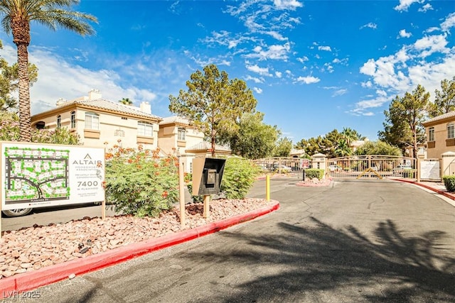 7400 W Flamingo Rd Unit 1051, Las Vegas, NV 89147 - view of asphalt road with curbs, a gate, and a gated entry