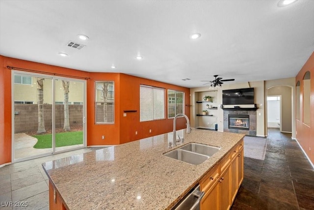 9413 Arcadia Woods Ct, Las Vegas, NV 89149 - kitchen with open floor plan, a tile fireplace, recessed lighting, a ceiling fan, and light stone counters