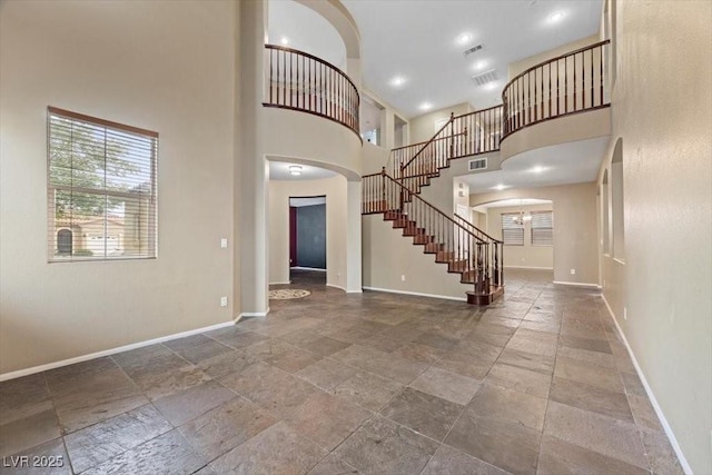 9413 Arcadia Woods Ct, Las Vegas, NV 89149 - entryway featuring stone tile floors, stairway, arched walkways, and a towering ceiling