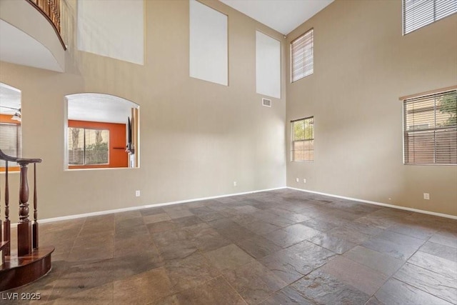 9413 Arcadia Woods Ct, Las Vegas, NV 89149 - empty room with a high ceiling, stone tile floors, healthy amount of natural light, and arched walkways