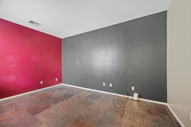 9413 Arcadia Woods Ct, Las Vegas, NV 89149 - unfurnished room featuring stone finish flooring and an accent wall