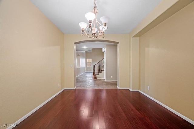 9413 Arcadia Woods Ct, Las Vegas, NV 89149 - unfurnished dining area featuring arched walkways, a chandelier, hardwood / wood-style flooring, and stairs
