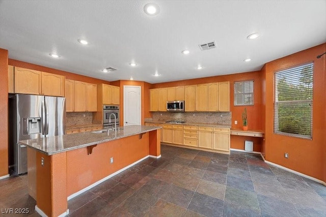 9413 Arcadia Woods Ct, Las Vegas, NV 89149 - kitchen with appliances with stainless steel finishes, decorative backsplash, light stone counters, recessed lighting, and a kitchen breakfast bar