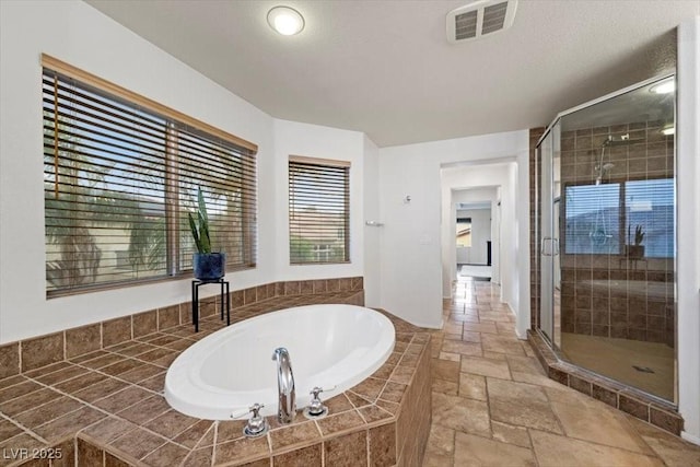 9413 Arcadia Woods Ct, Las Vegas, NV 89149 - bathroom featuring stone tile floors, a bath, and a shower stall