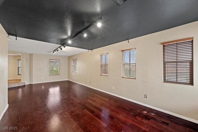 9413 Arcadia Woods Ct, Las Vegas, NV 89149 - empty room with track lighting, wood-type flooring, plenty of natural light, and a textured ceiling