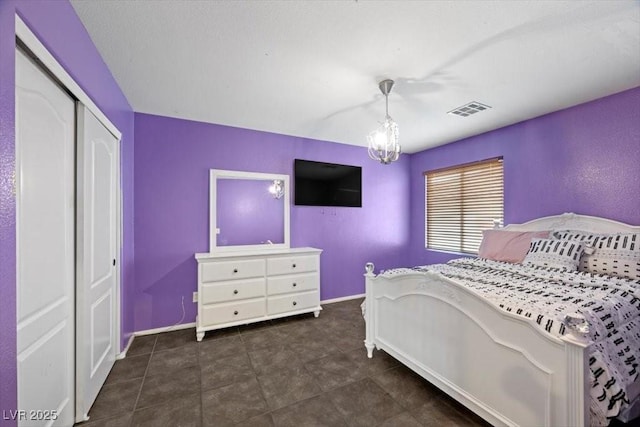 9413 Arcadia Woods Ct, Las Vegas, NV 89149 - bedroom featuring a chandelier, a closet, and dark tile patterned flooring