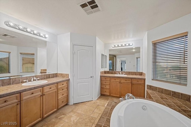 9413 Arcadia Woods Ct, Las Vegas, NV 89149 - full bath featuring a garden tub, two vanities, and stone tile flooring