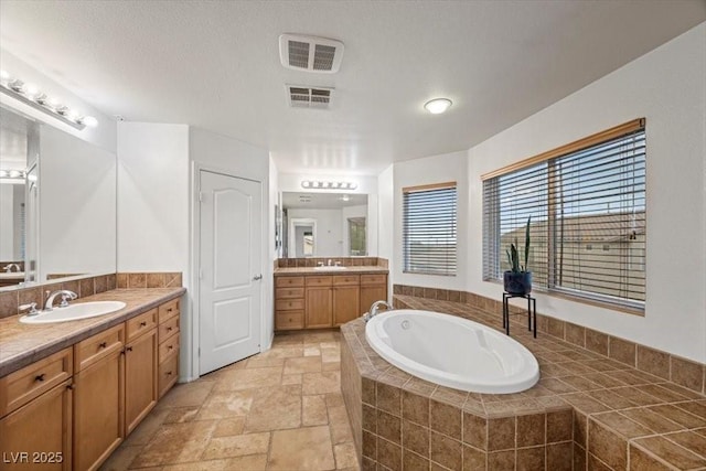 9413 Arcadia Woods Ct, Las Vegas, NV 89149 - full bath featuring a bath, stone tile flooring, and two vanities