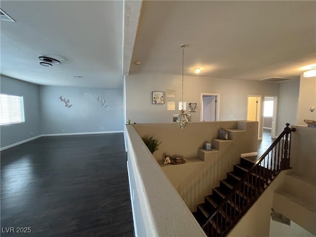 staircase featuring baseboards and wood finished floors